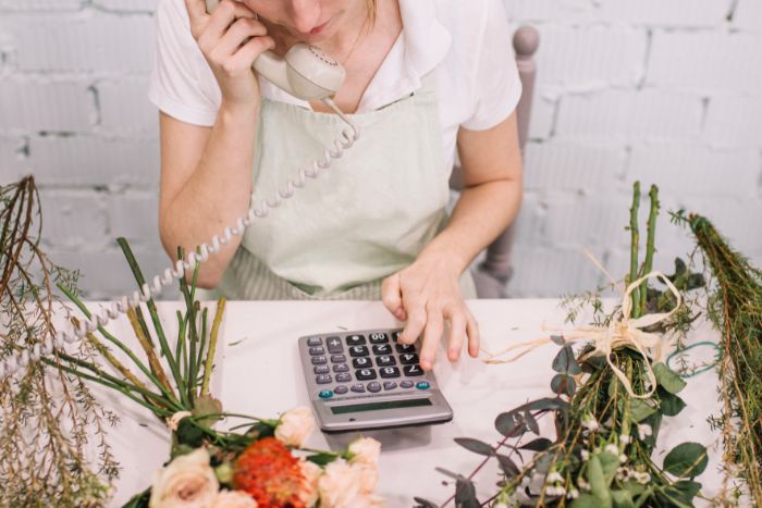 Mulher calculando e no telefone