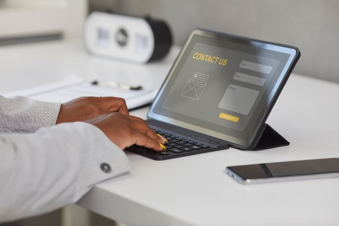 Homem mexendo em um notebook na mesa.