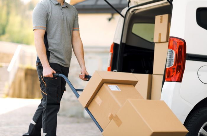 Entregador descarregando encomendas dentro do prazo de entrega.