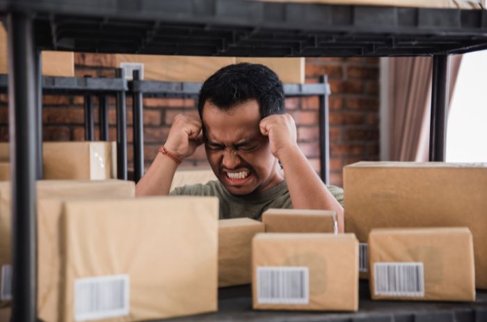 Homem com dor de cabeça por conta de estoque parado.