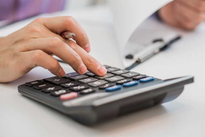 Mão calculando com calculadora