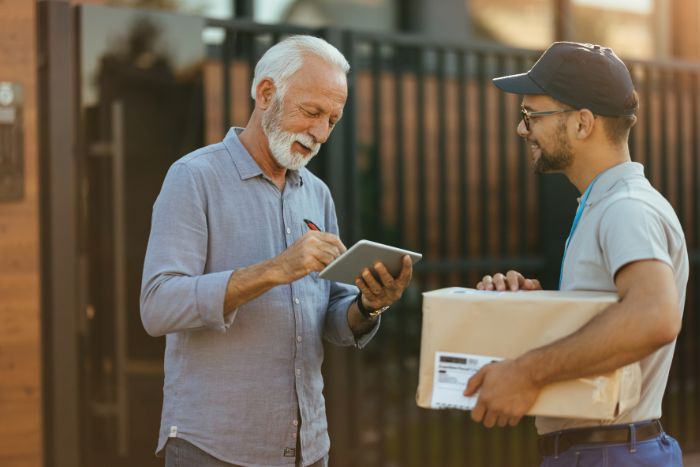 Entregador entregando encomenda a cliente.