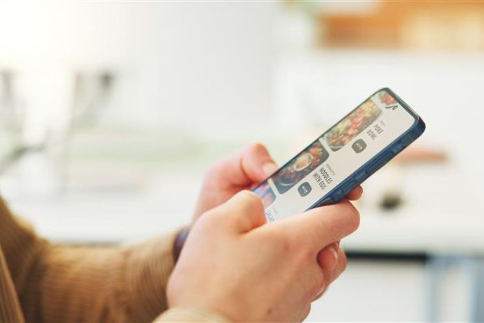 Pessoa teclando na internet pelo celular.