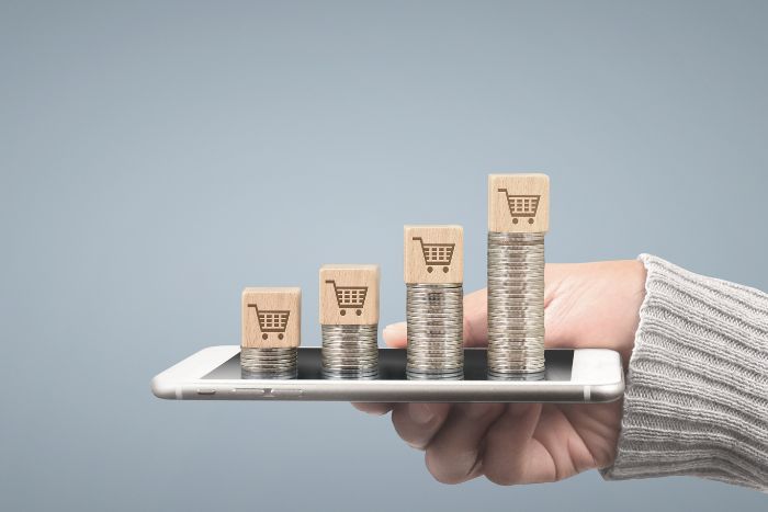 Moedas empilhadas em cima de um celular.