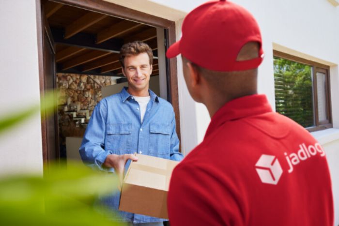 Entregador da Jadlog entregando encomenda para o cliente.